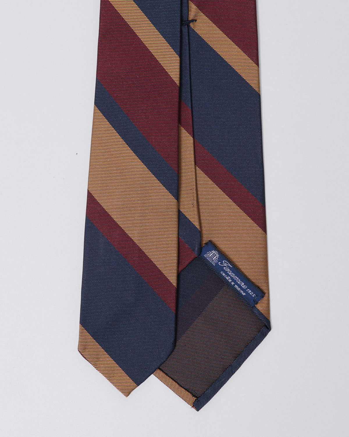Unlined silk regimental tie in shades of blue, burgundy, and sand