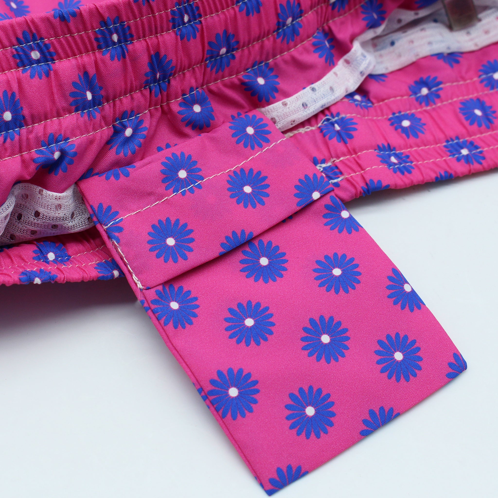 Costume da bagno rosso o rosa con fiori blu. Asciugatura rapida