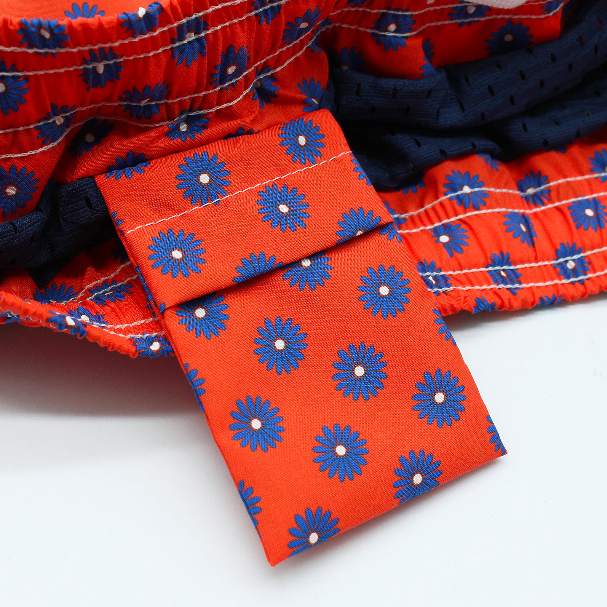 Costume da bagno rosso o rosa con fiori blu. Asciugatura rapida